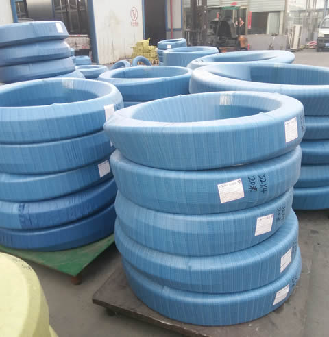 A worker is packing hydraulic hose with packing belt.